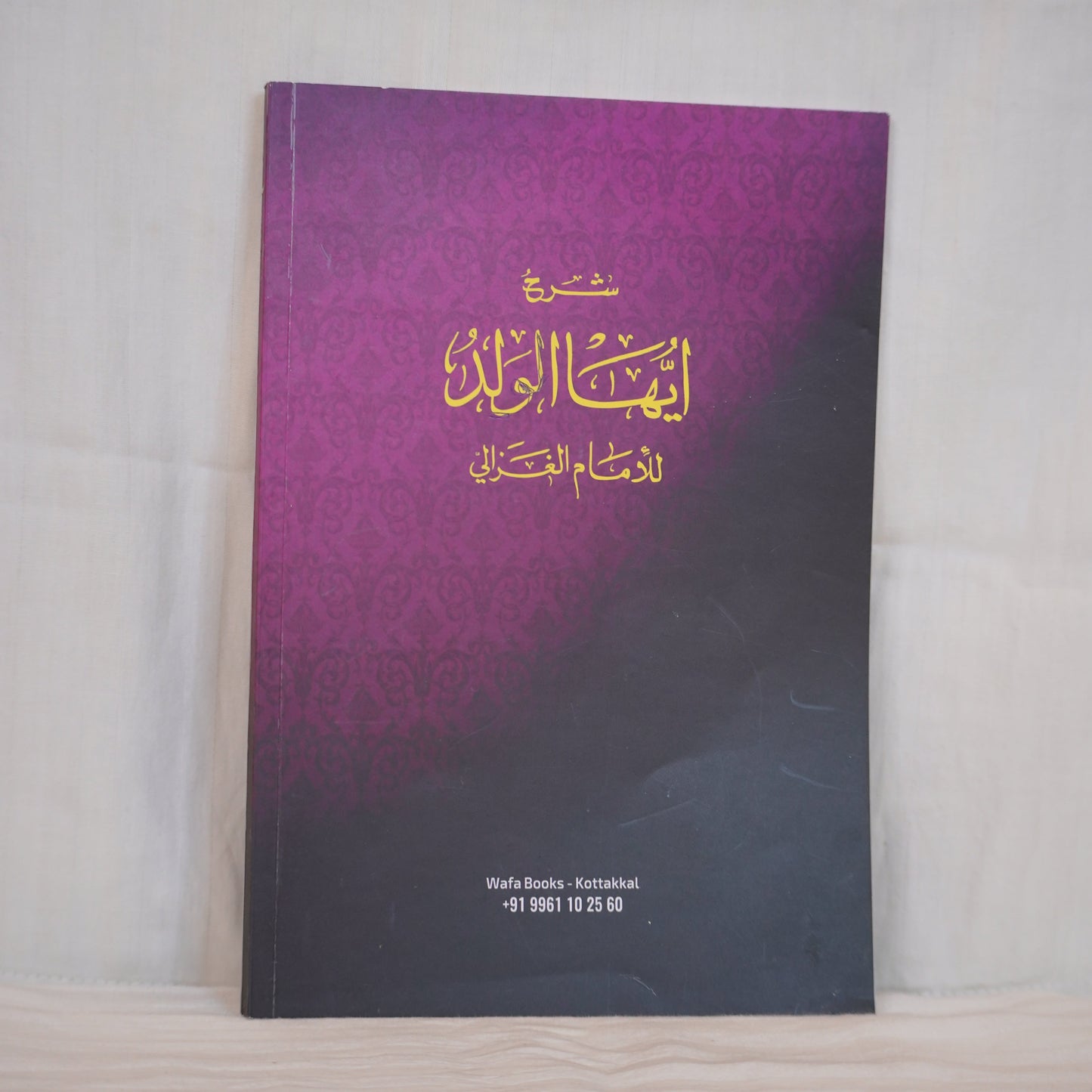 Back cover of Sharh Ayyuha Al-Walad Islamic book. Features Arabic text in gold on a purple gradient background with a decorative pattern.