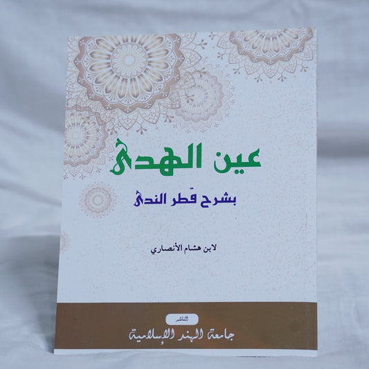 Front Cover of the Arabic grammar book 'Aynul Huda Sharh Qatrun Nada' by Ibn Hisham Al-Ansari, published by Jamiathul Hind Al Islamiyya, featuring a floral background and traditional Islamic design.