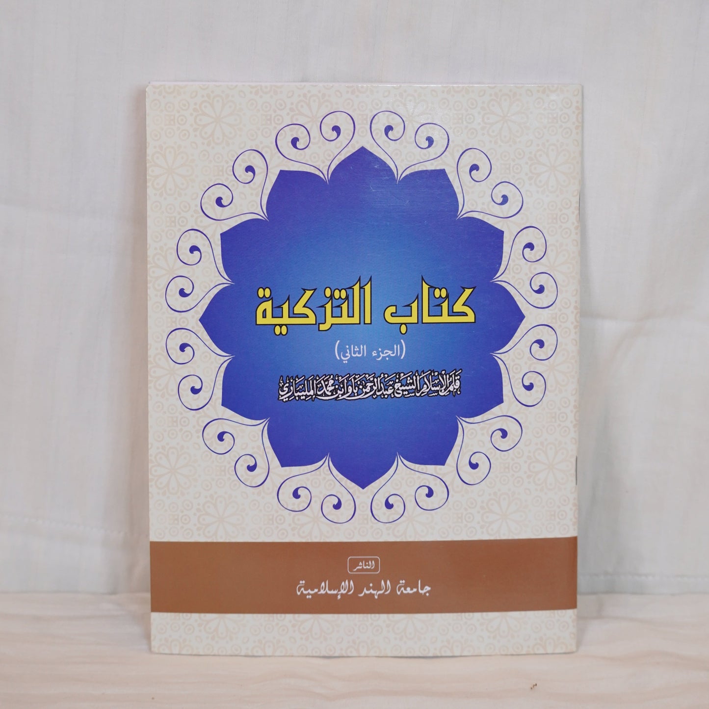 Front cover of Kitabu Tazkiyah (Part 2), an Arabic book on spiritual purification, featuring a white and blue floral design.