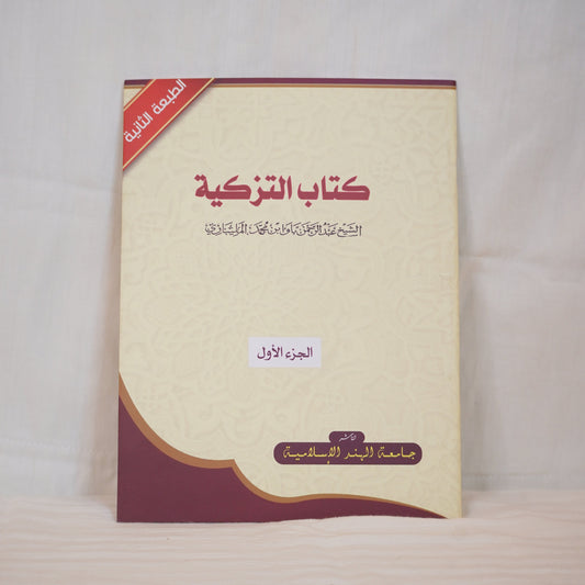 A book cover with Arabic text titled Kitab Al-Tazkiyah (Book of Purification) - Part One. The cover has a beige background with maroon and gold design elements. The book is authored by Shaikh Abdurahman Bava Bnu Muhammed Malibhari and published by Jamiathul Hind Al-Islamiya. A red banner in the top left corner indicates this is the second edition.