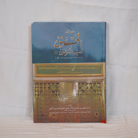 Moulid ul Husnain li Sayyedil Kounain by Abdul Basheer Saqafi Pilakkal – A book with Arabic calligraphy and an image of the Prophet’s Mosque.