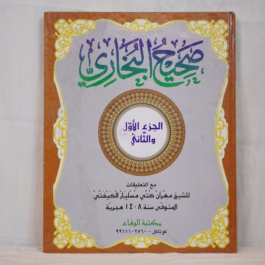 A book cover featuring Arabic calligraphy with decorative golden borders. The title in Arabic reads "Sahih Al-Bukhari," indicating a collection of Hadith. The cover includes additional text about the author and publisher. The background is light gray with intricate golden designs, and the book appears to have a hardcover binding.